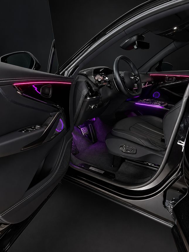 Aston Martin DBX: открытая дверь водителя, розовый контур и фиолетовые ноги