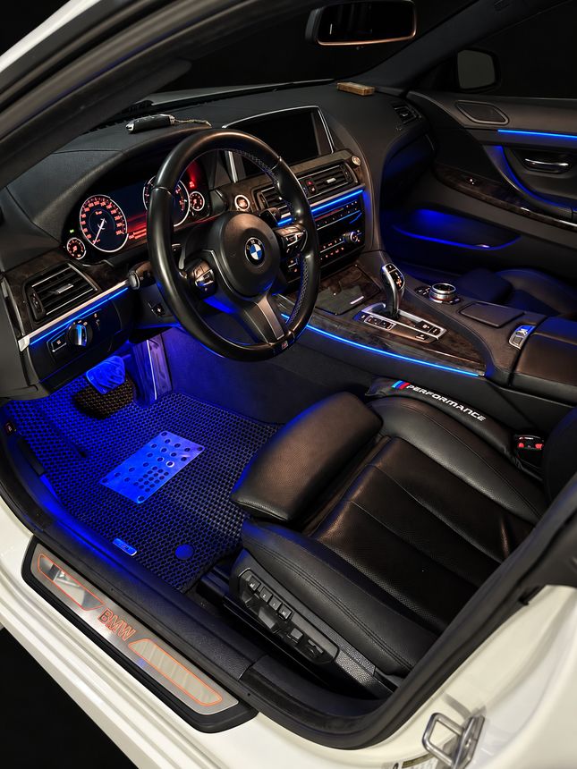 BMW 6 серия F06: место водителя через открытую дверь, синие ноги