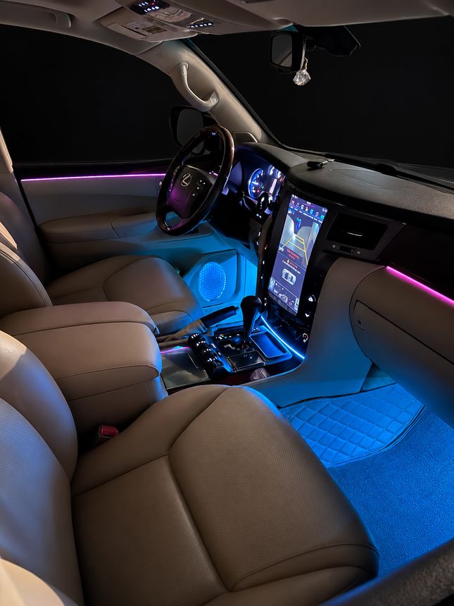 Lexus LX: руль, торпедо и консоль, розовый контур и голубые ноги